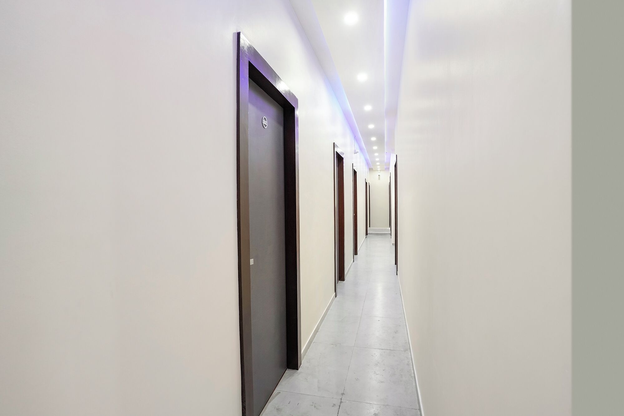 A long, narrow hallway with doors on both sides, leading to individual rooms.