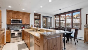 Una cocina moderna con armarios de madera, electrodomésticos de acero inoxidable y una isla grande.