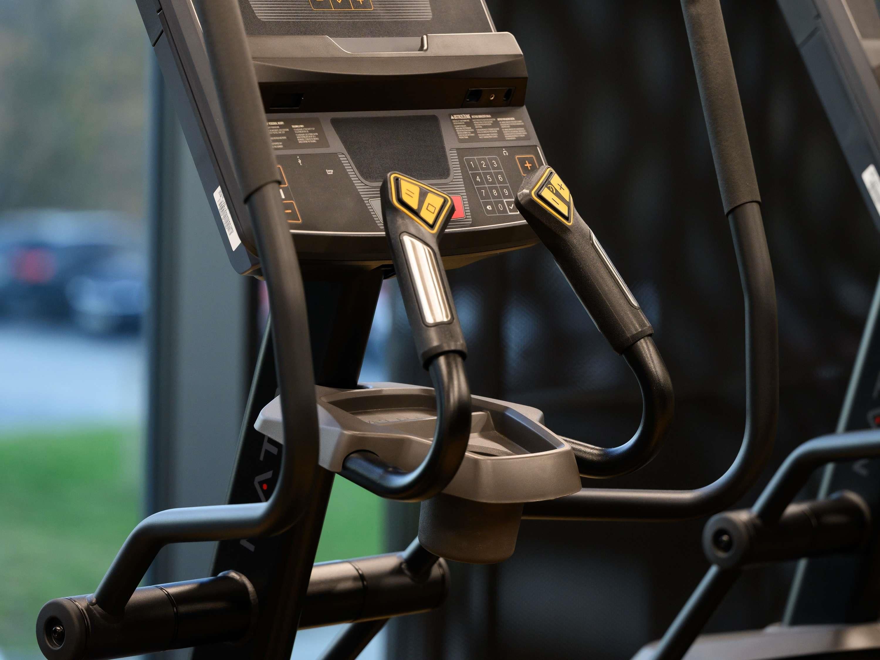 Una bicicleta estática con panel de control, pedales y asiento.
