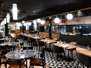 A restaurant interior with multiple dining tables, chairs, and pendant lighting. - Mercure Szczyrk Resort (Szczyrk)
