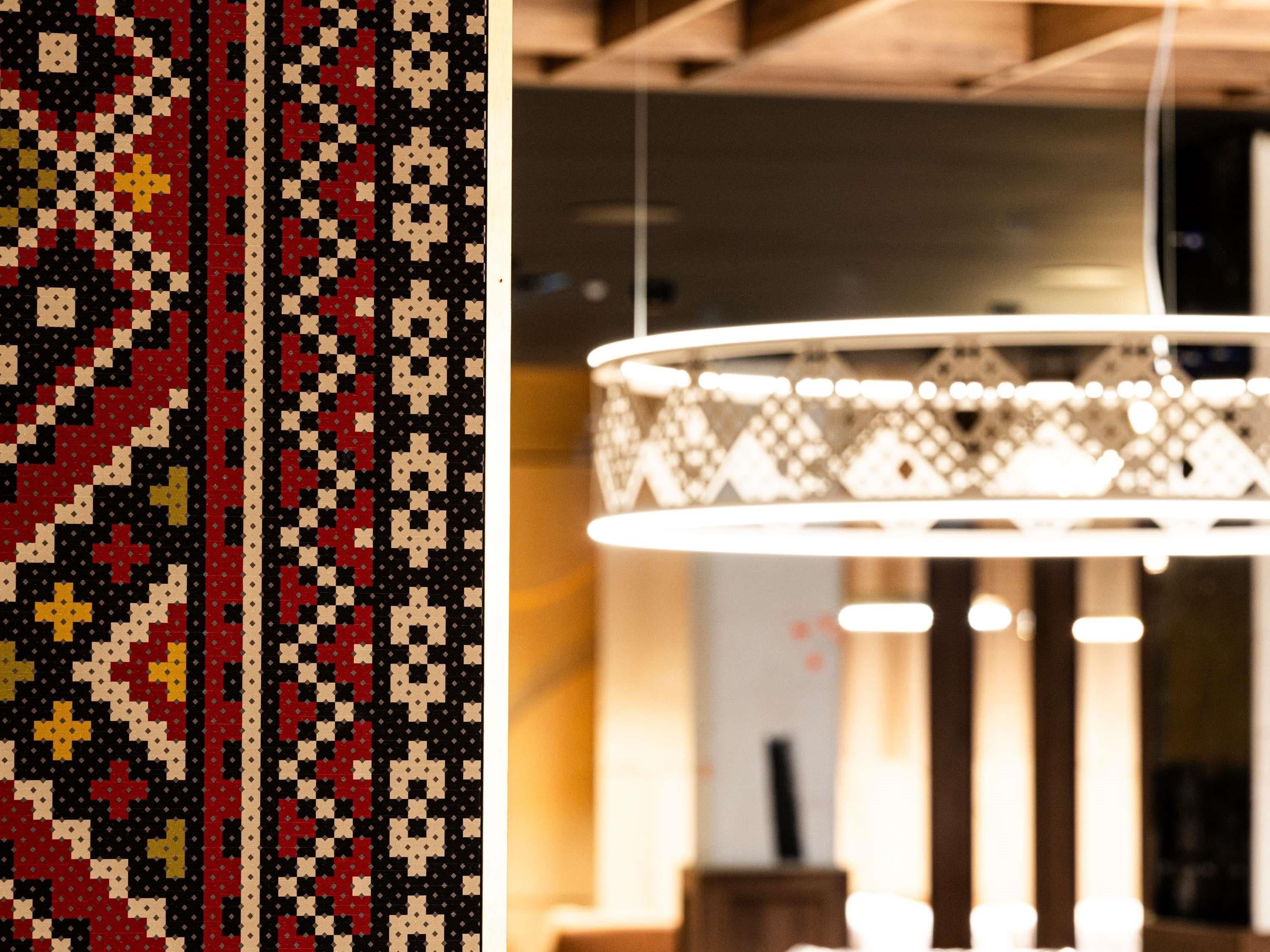 A patterned wall and a modern chandelier.