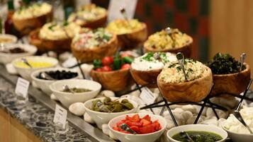 A buffet with various dishes served in bowls and baskets.