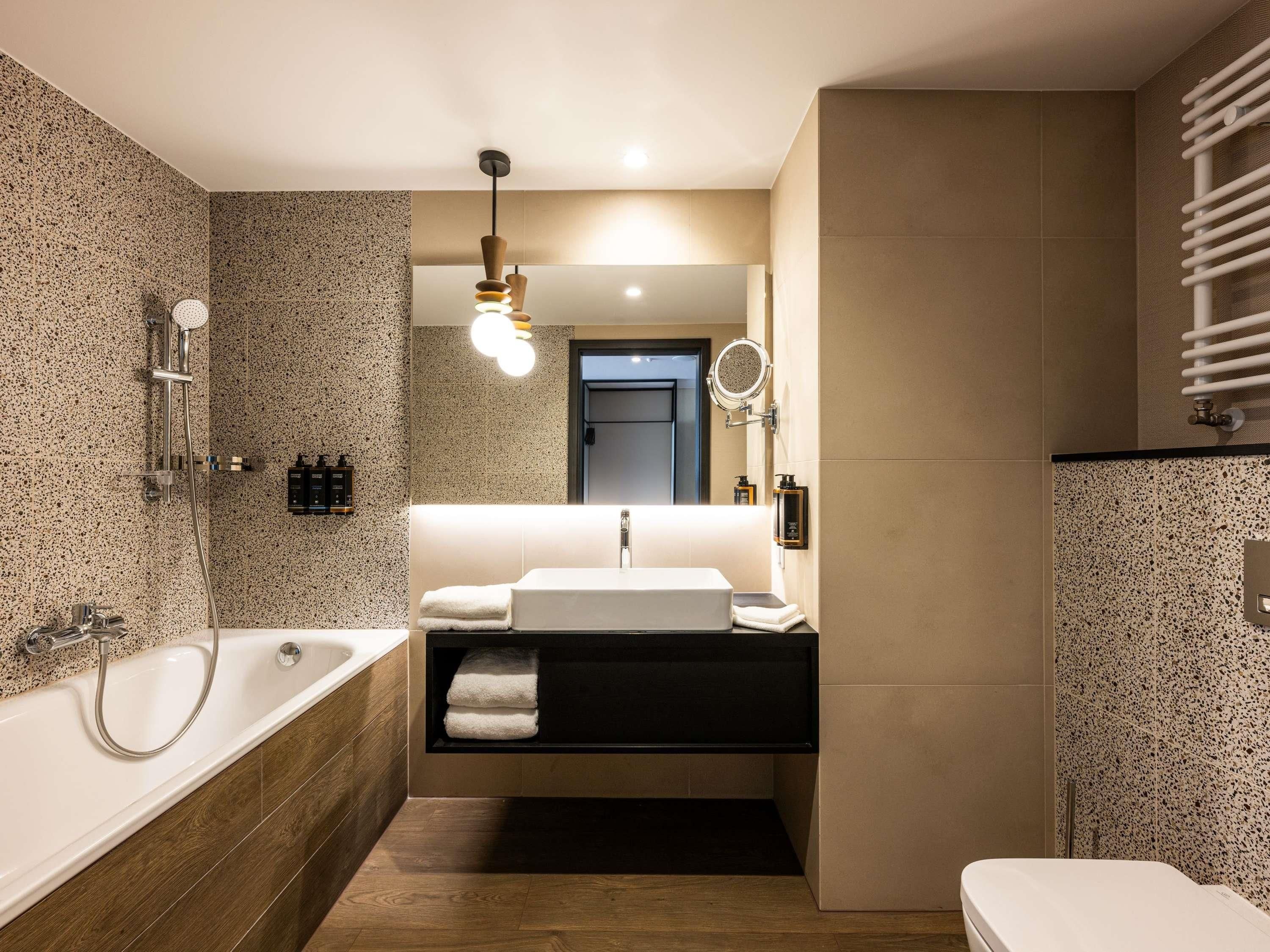 A modern bathroom with a freestanding bathtub, a vanity with a mirror, and a toilet.