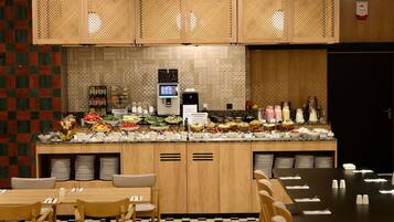 A buffet setup with various food items and a self-service coffee station.