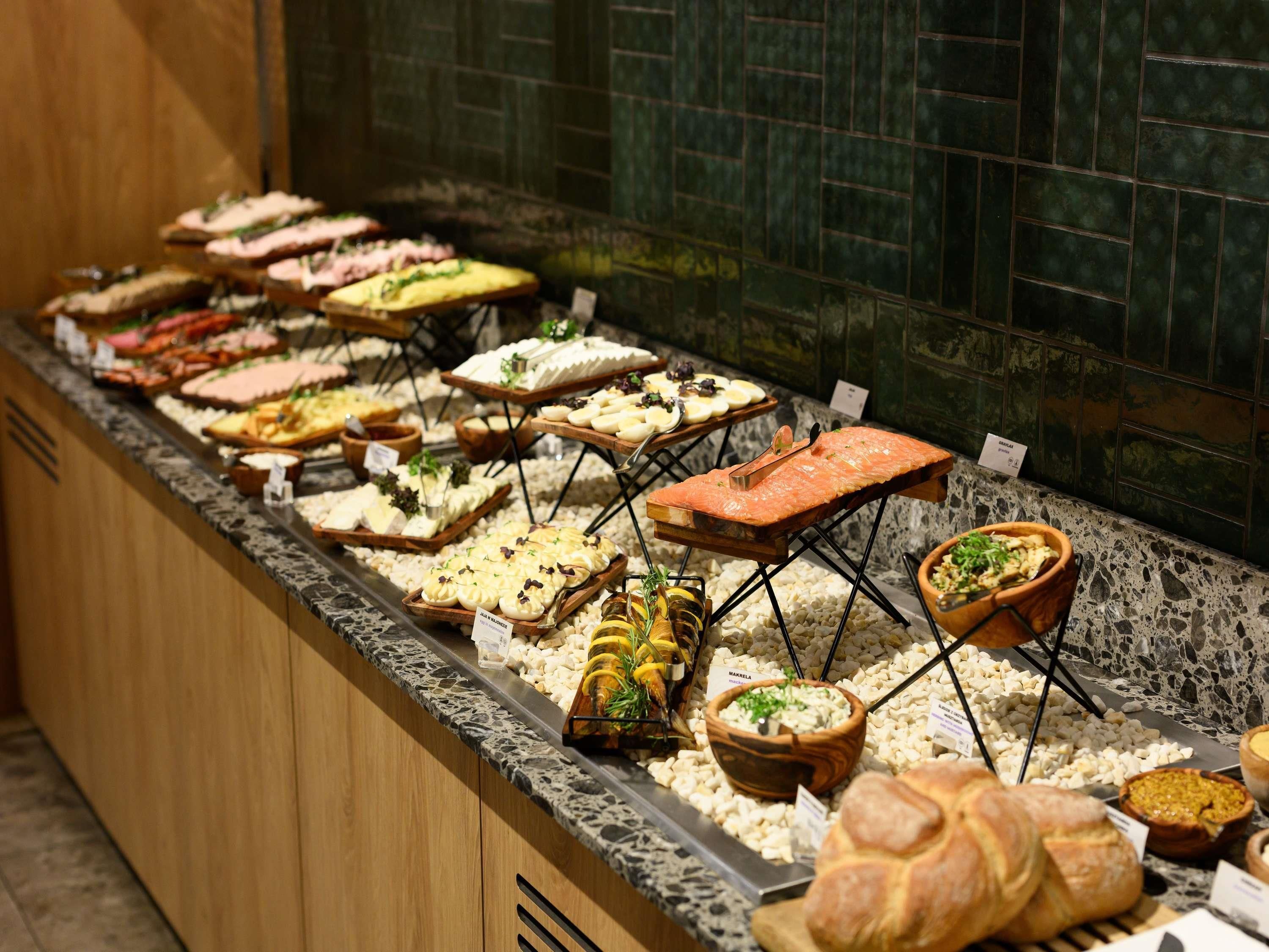A buffet with various food items and a wooden counter.