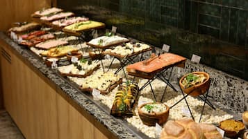 A buffet with various food items and a wooden counter.