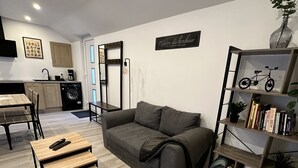 A modern living room with a grey sofa, wooden coffee table, and a bookshelf. - Chez Fanf et Nanie (Isigny-sur-Mer)