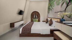 A modern hotel bedroom with a large bed, a TV mounted on the wall, a bench, and a decorative wall mural. - BIG HOTEL (Hue)
