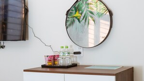 A modern bathroom with a wooden vanity, a round mirror, and a small stool. - BIG HOTEL (Hue)