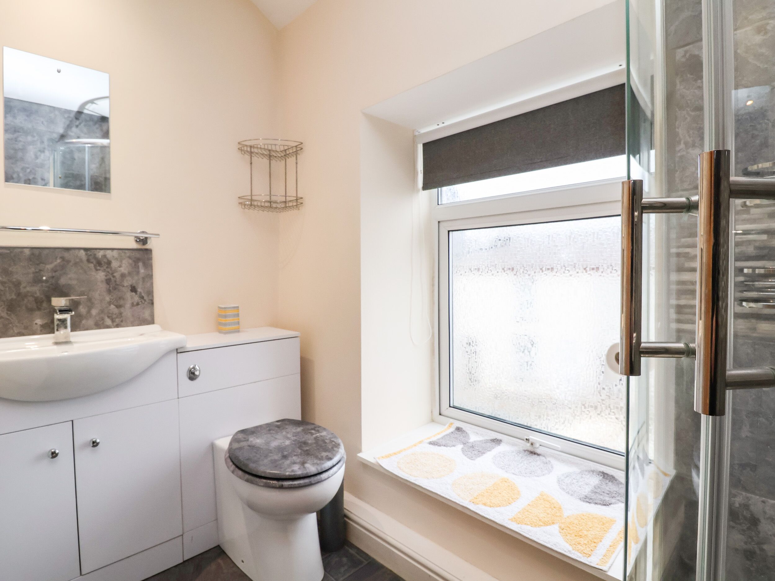 Un baño moderno con inodoro, lavamanos y ventana.