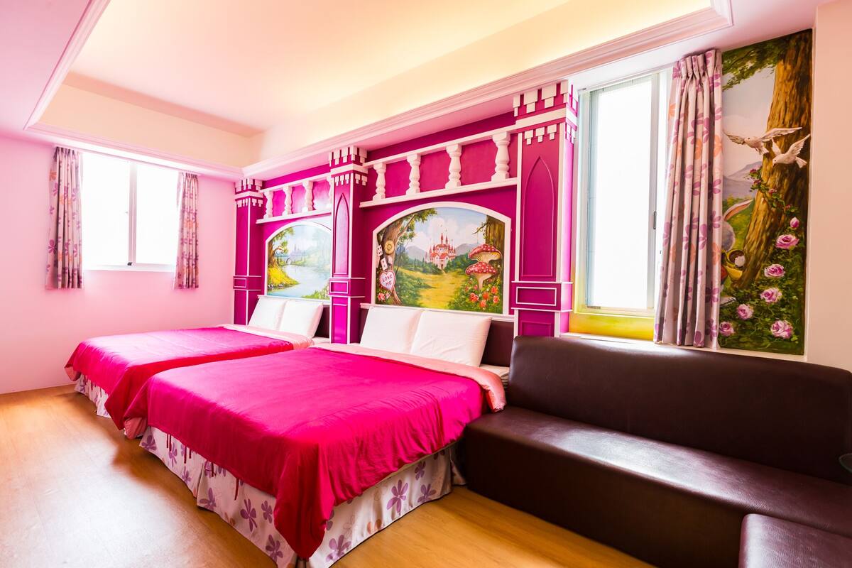 A pink-themed bedroom with two beds, a brown sofa, and a mural of a castle and forest.