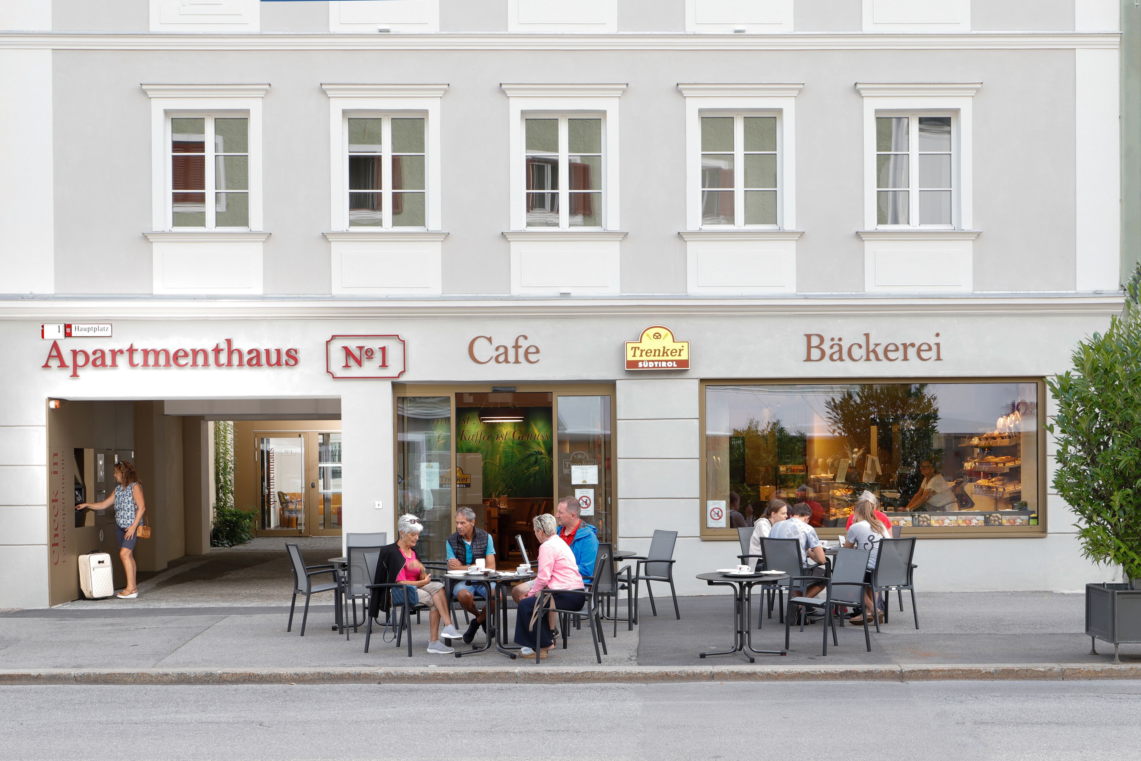 Un caffè con tavoli all'aperto, ingresso ben visibile e insegna che indica il numero uno in via.