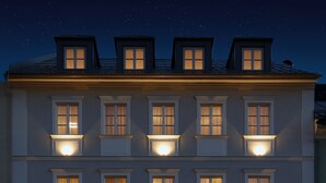 Um edifício de vários andares com janelas iluminadas e um café no andar térreo.