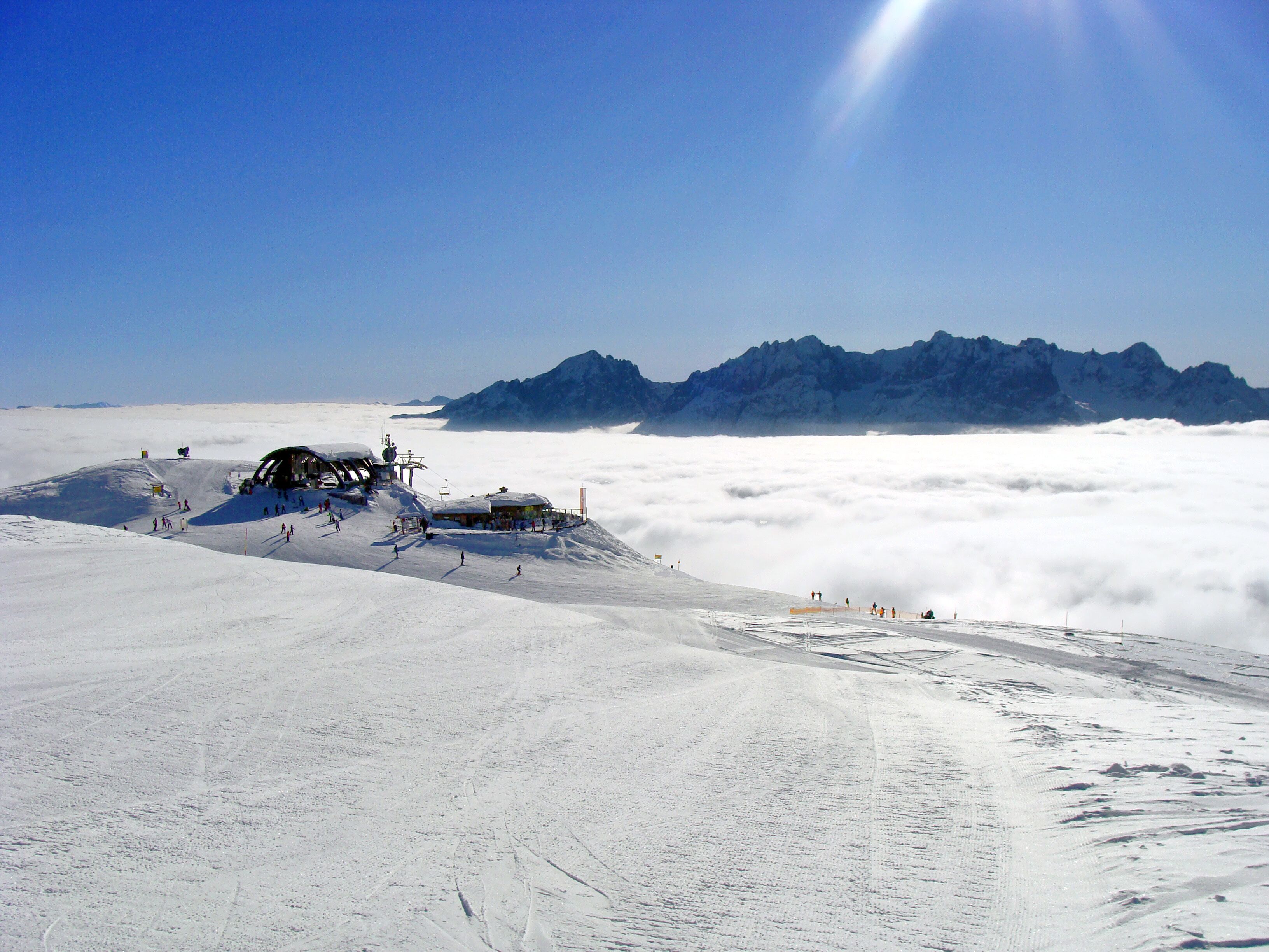 A snow-covered mountain with a ski lift and a mountain lodge.