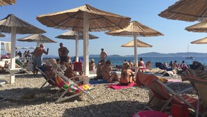 A beach with umbrellas and people relaxing. - Holiday Home Biograd na Moru With Private Pool Minutes From Adriatic Sea (Benkovac)