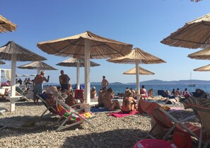 A beach with umbrellas and people relaxing. - Holiday Home Biograd na Moru With Private Pool Minutes From Adriatic Sea (Benkovac)