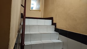 Eine Treppe mit weißen Fliesen und einem Holnänder.