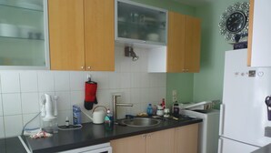 Een keuken met een vaatwasser, fornuis, spoelbak en kastjes.
