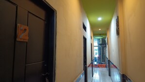 A hotel corridor with a green ceiling, tiled floors, and a door marked with the number 2. - OYO 93485 Hotel Kenzie Sentani (Sentani)