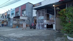 A hotel entrance with a sign for 'Hotel Transit Kenzie' and a 'Laundry Murah Express' sign. - OYO 93485 Hotel Kenzie Sentani (Sentani)