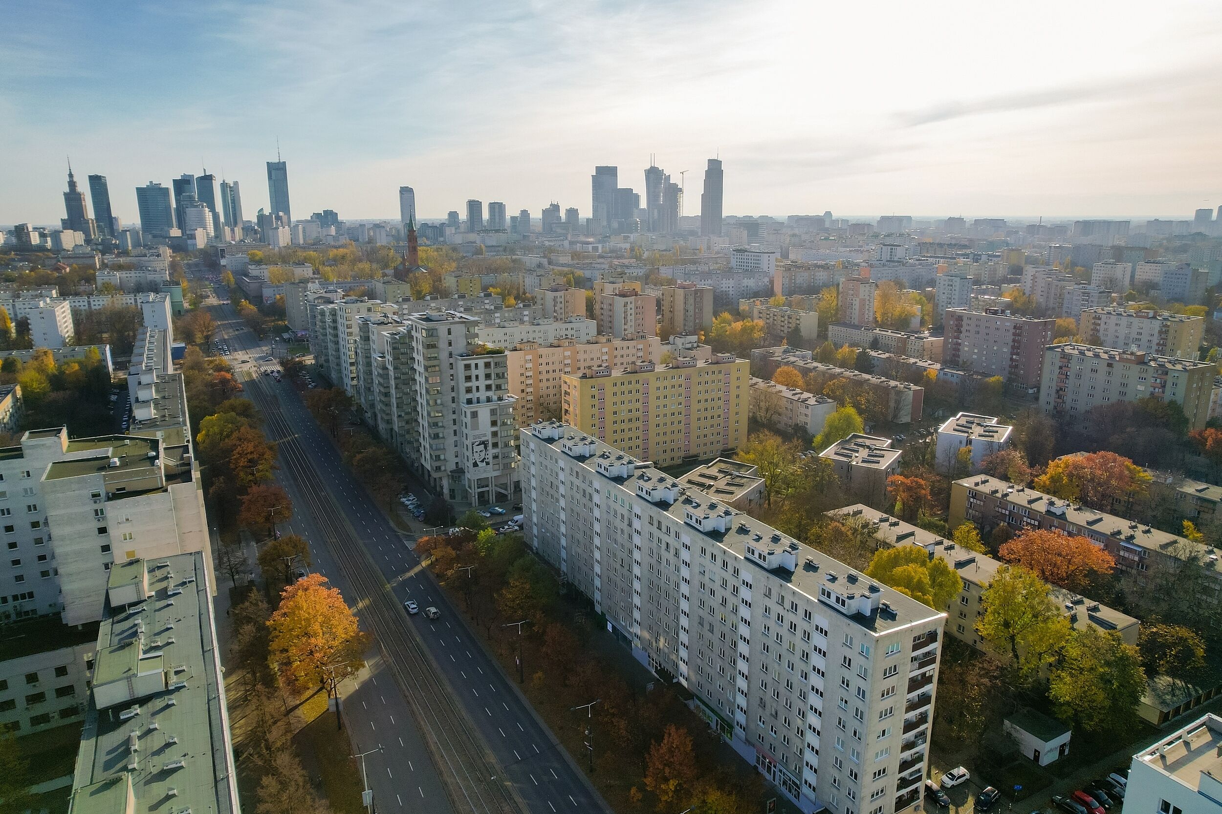 Ein Hochhaus mit mehreren Stockwerken, umgeben von anderen Gebäuden und Bäumen.