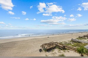 Une plage avec une promenade en bois et une vue dégagée sur l’océan.
