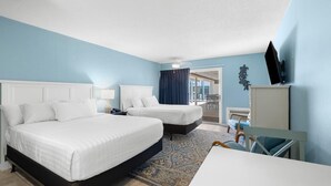 A hotel room with two beds, a desk, a TV, and a view of the outside. - Pool View Room First Floor Sleeps 4 (Pawleys Island)