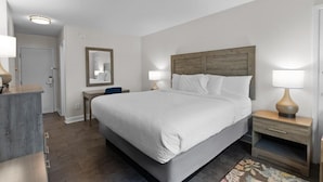 A neatly arranged hotel room with a large bed, bedside tables, a mirror, and a wooden headboard. - King Bed Close to Beach Resort View (Pawleys Island)