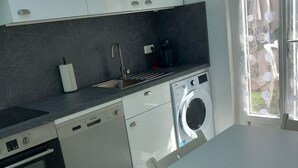 A modern kitchen with a dishwasher, oven, and washing machine.