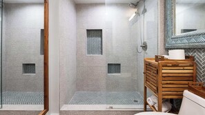 Une salle de bain moderne avec un espace douche, un meuble-lavabo en bois et un miroir.