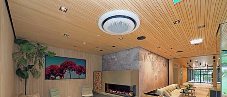 Una sala de estar moderna con chimenea, sofás y una mesa de centro.
