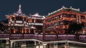 A traditional Chinese building with ornate architecture, a bridge, and a reflection in the water. - Novotel Shanghai Jingan (Shanghai)