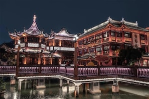 A traditional Chinese building with ornate architecture, a bridge, and a reflection in the water. - Novotel Shanghai Jingan (Shanghai)
