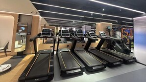A modern gym with multiple treadmills, each equipped with digital displays. - Novotel Shanghai Jingan (Shanghai)
