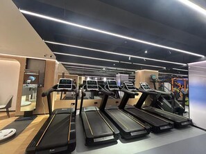 A modern gym with multiple treadmills, each equipped with digital displays. - Novotel Shanghai Jingan (Shanghai)