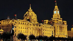 A large, historic building with a prominent dome and clock tower, illuminated at night. - Novotel Shanghai Jingan (Shanghai)