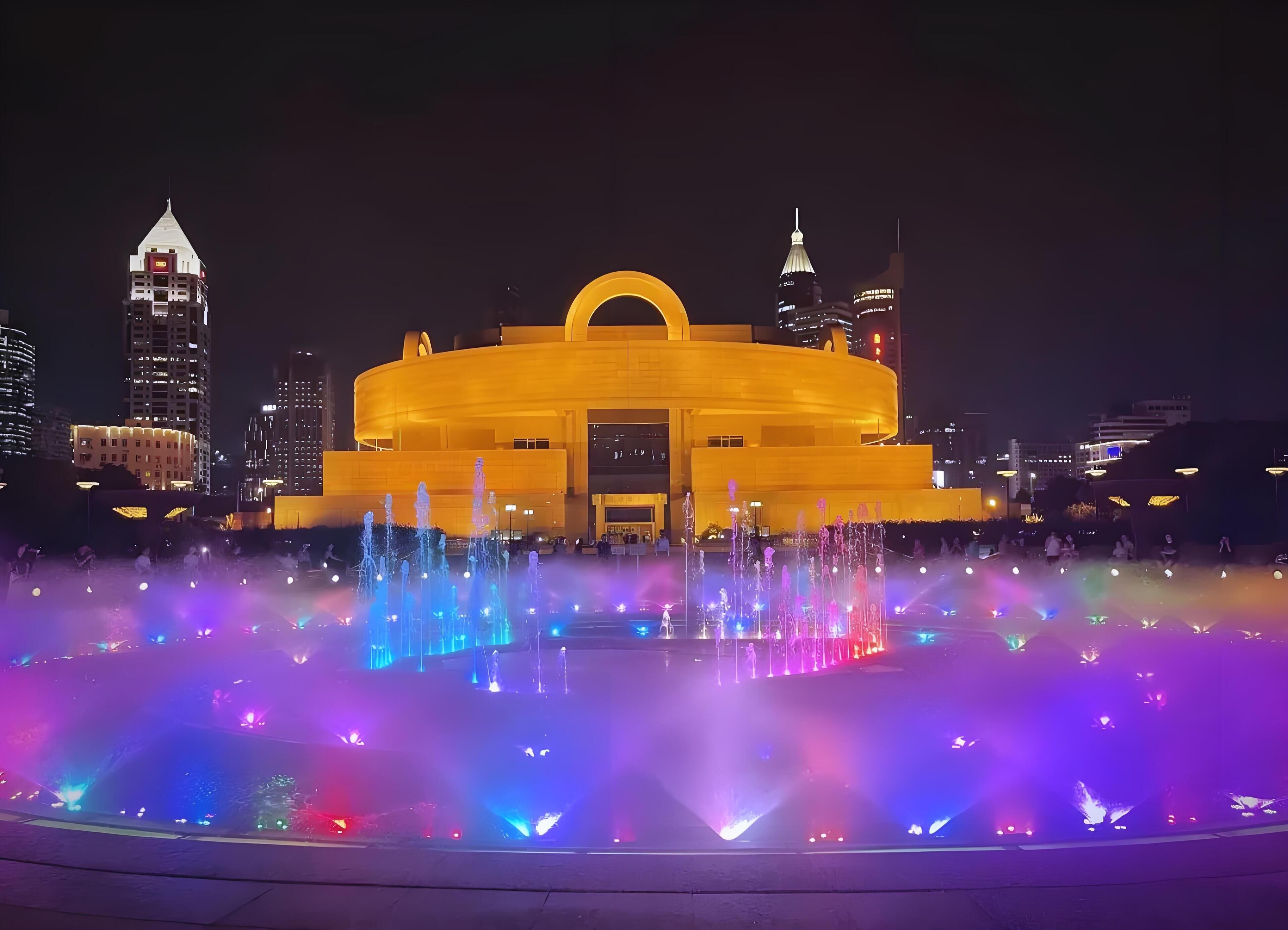 Un grand bâtiment circulaire, doté d’une entrée imposante et d’une fontaine à l’avant.