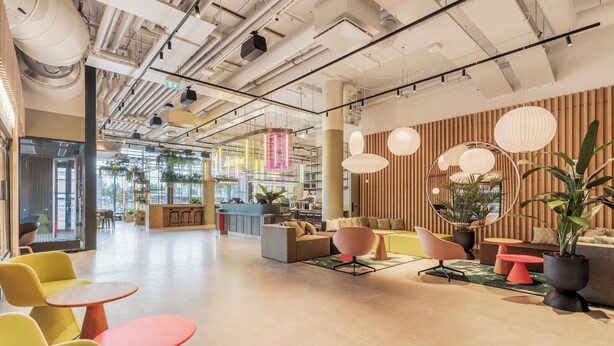 Een modern interieur met zithoeken, een receptiebalie en uitzicht op buiten.