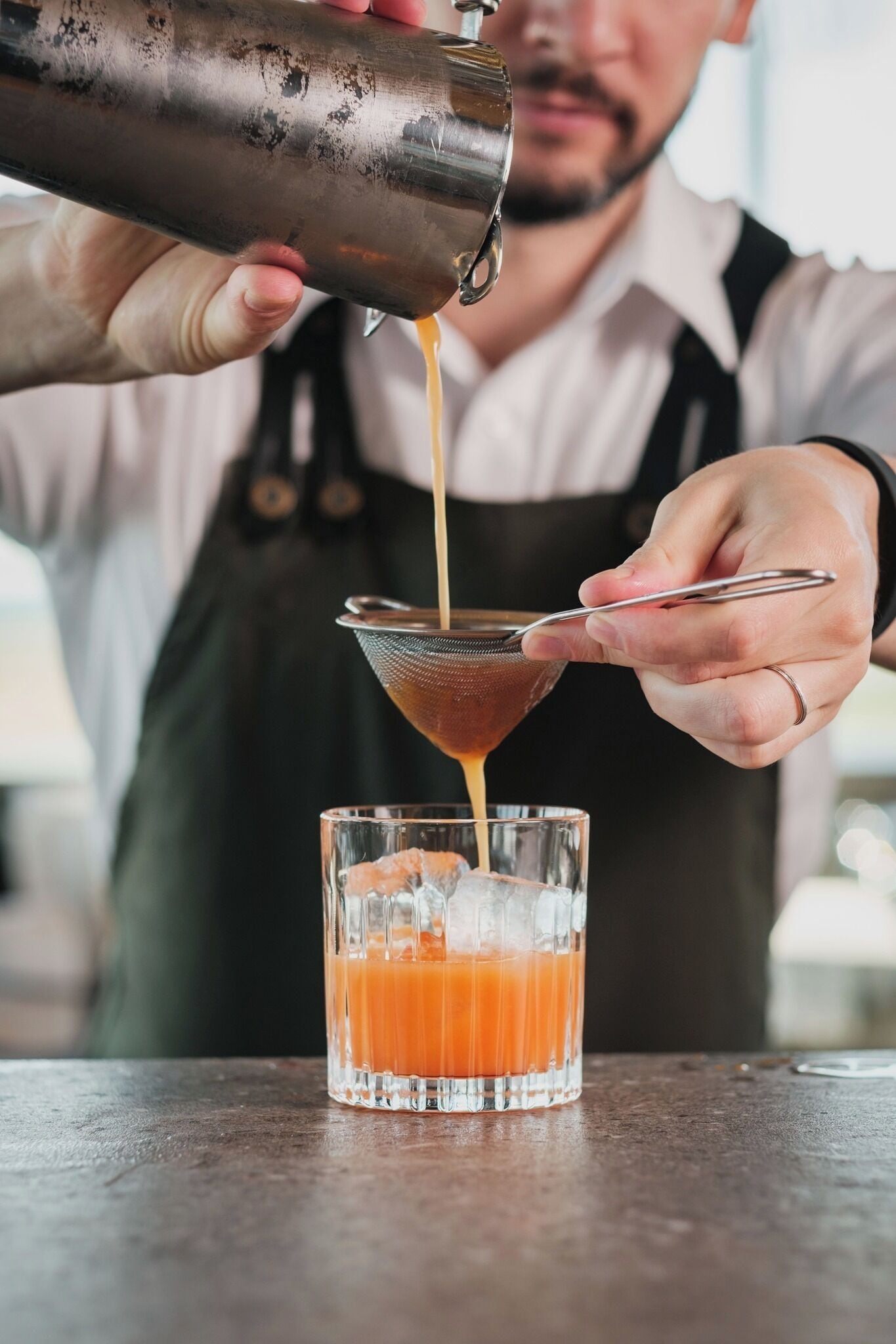 A person pouring a drink into a glass.