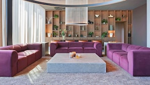 Ein modernes Wohnzimmer mit einer großen Sofagarnitur, einem Couchtisch und einer dekorativen Lampe.