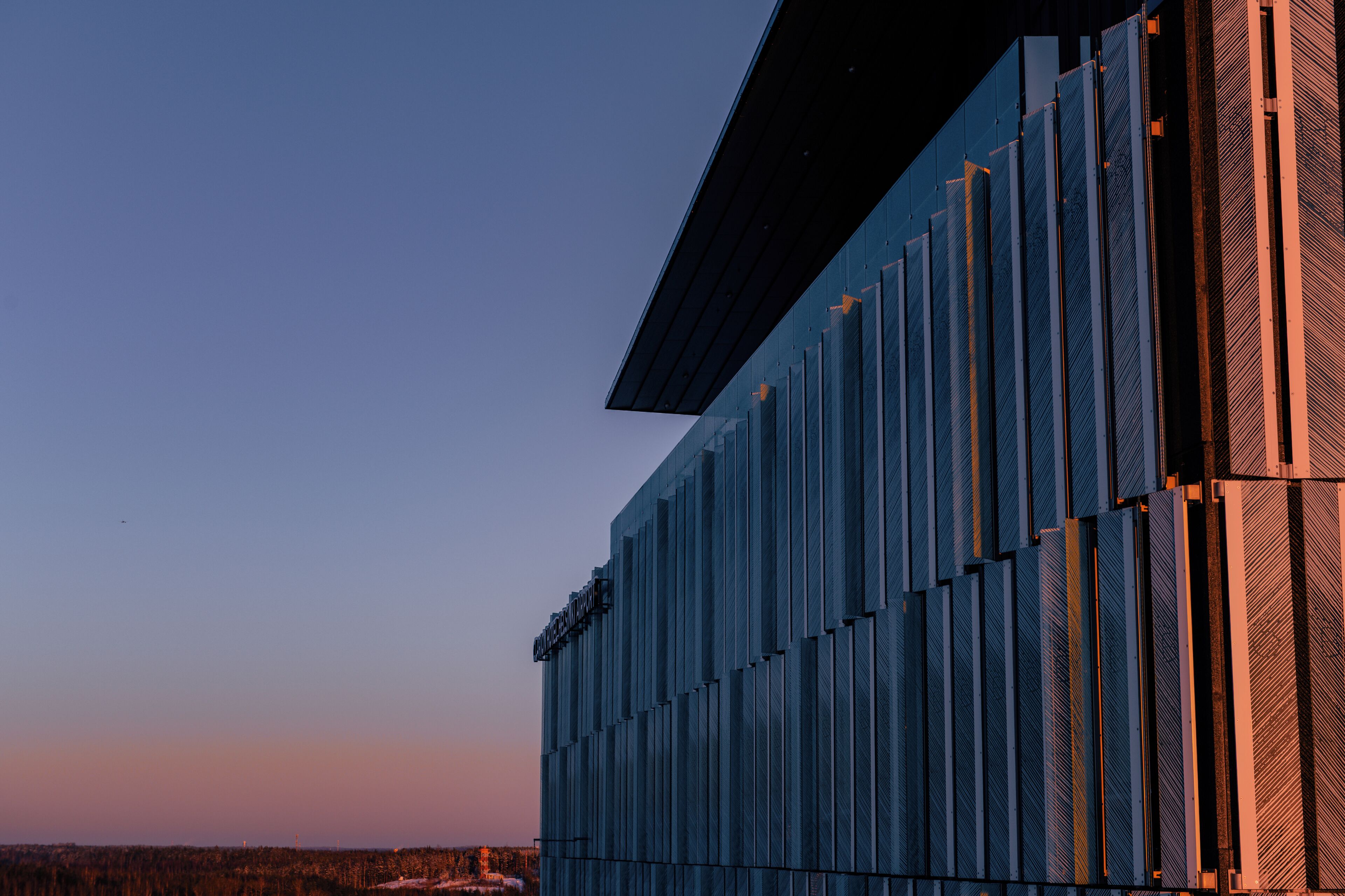Ein modernes Gebäude mit einer Reihe vertikaler Fenster und einem flachen Dach.