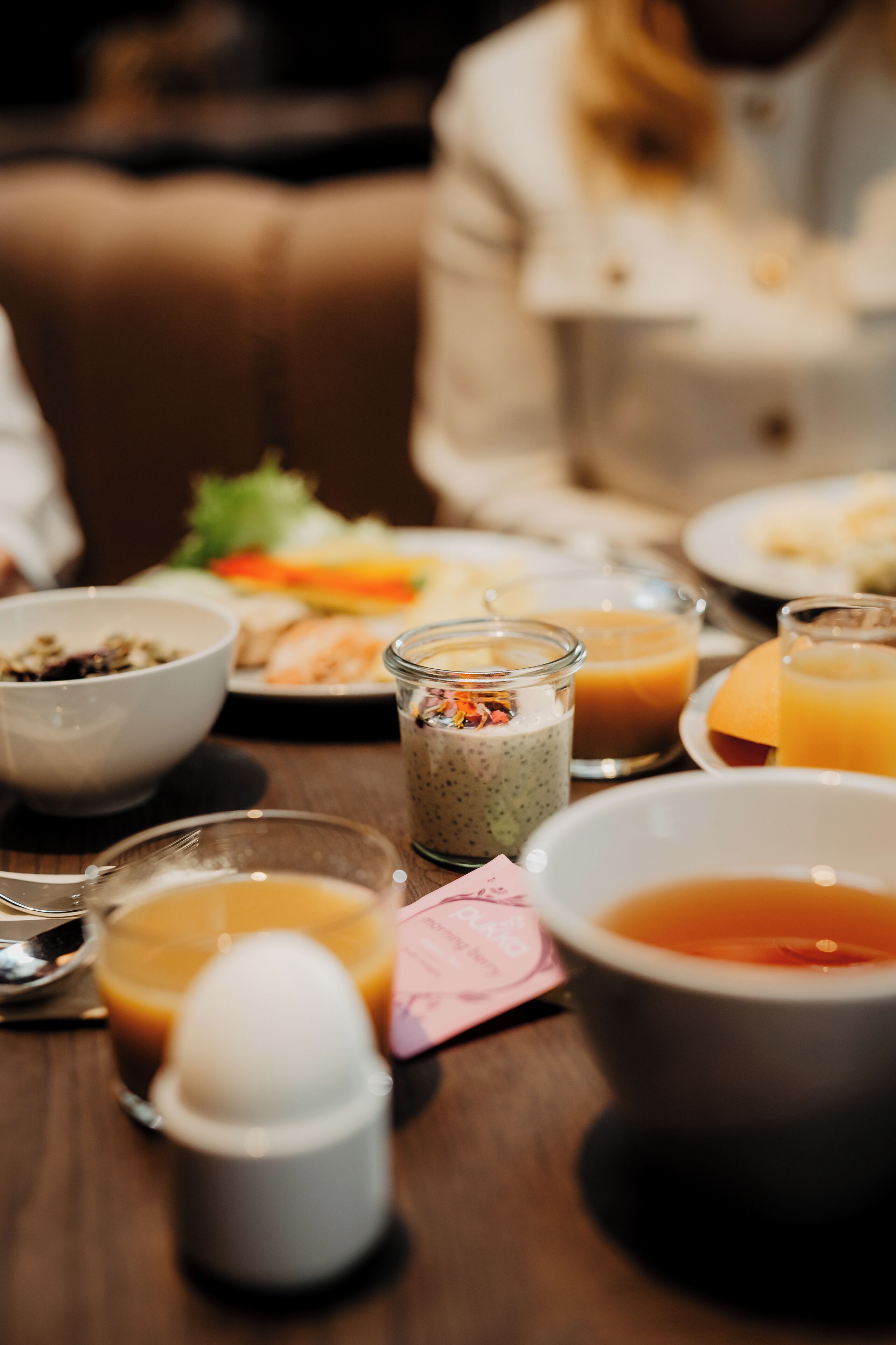 A dining table with various food items and beverages.