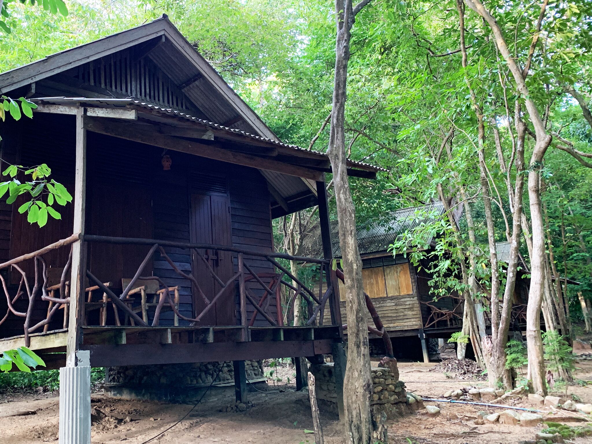 Eine rustikale Holzhütte mit Veranda, umgeben von Bäumen.