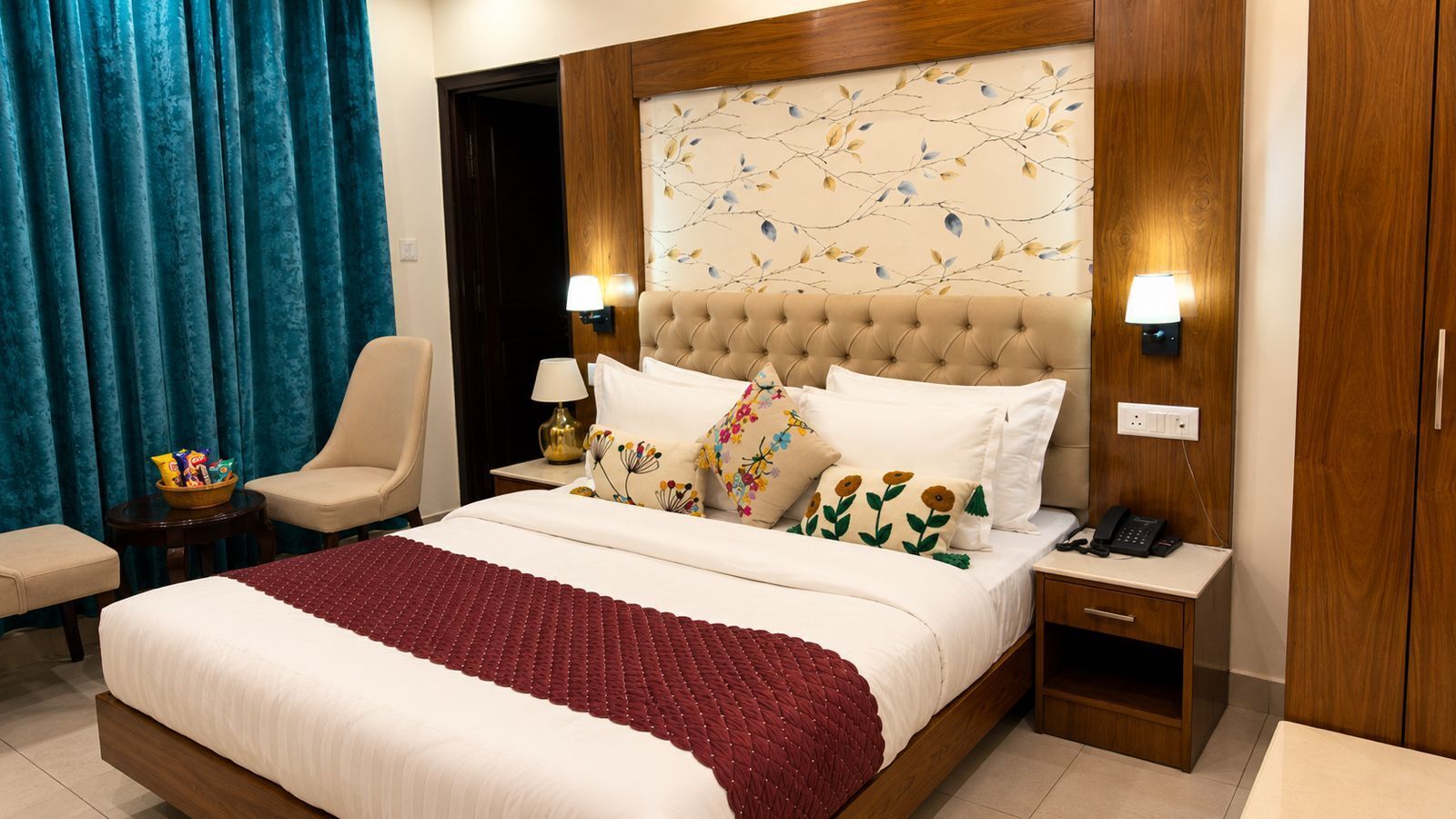 Une chambre d’hôtel avec un grand lit, deux tables de chevet, une chaise et une armoire.