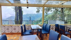 A restaurant with a terrace overlooking a mountainous landscape.