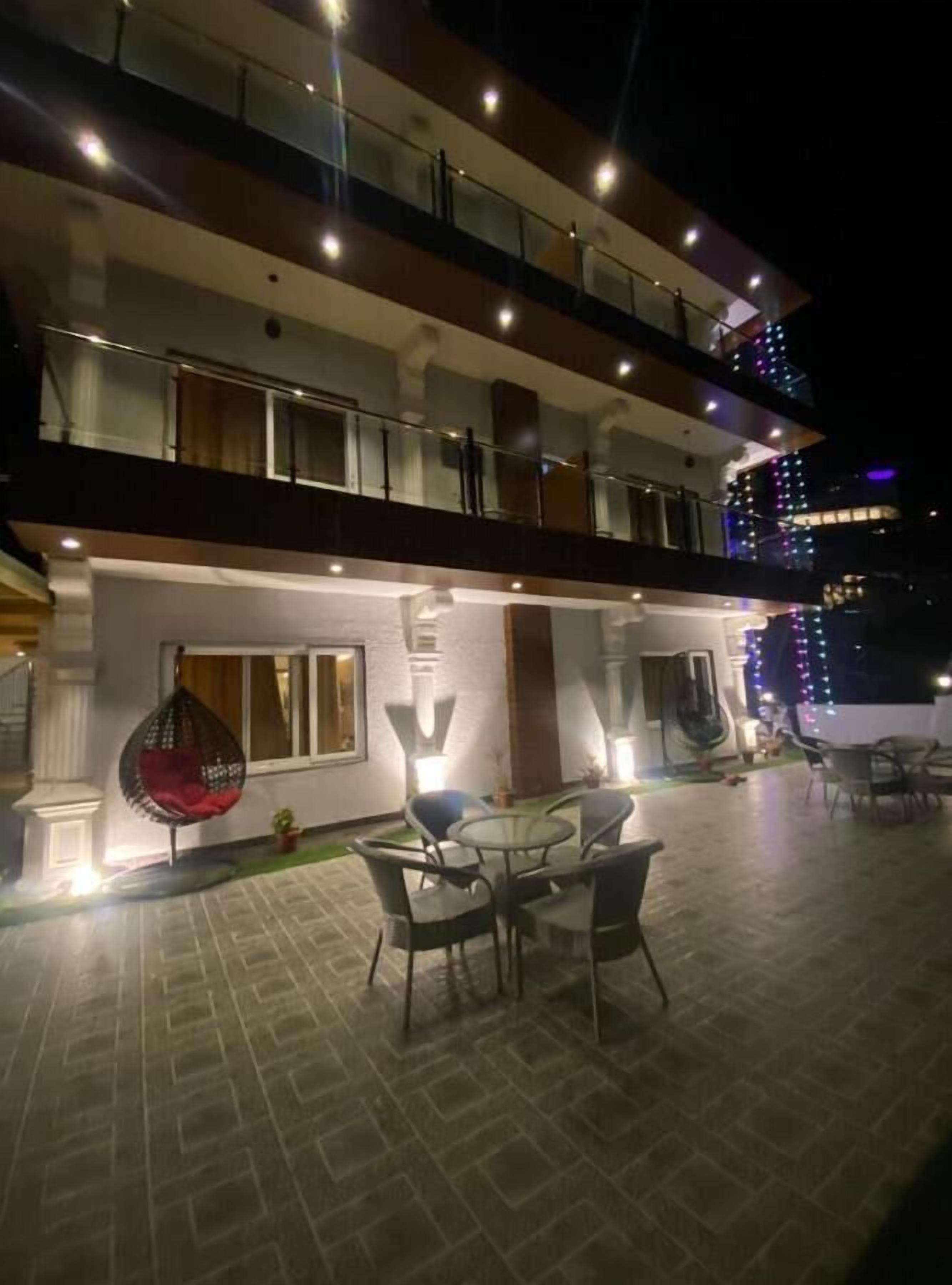 A multi-story building with outdoor seating and a hanging chair.