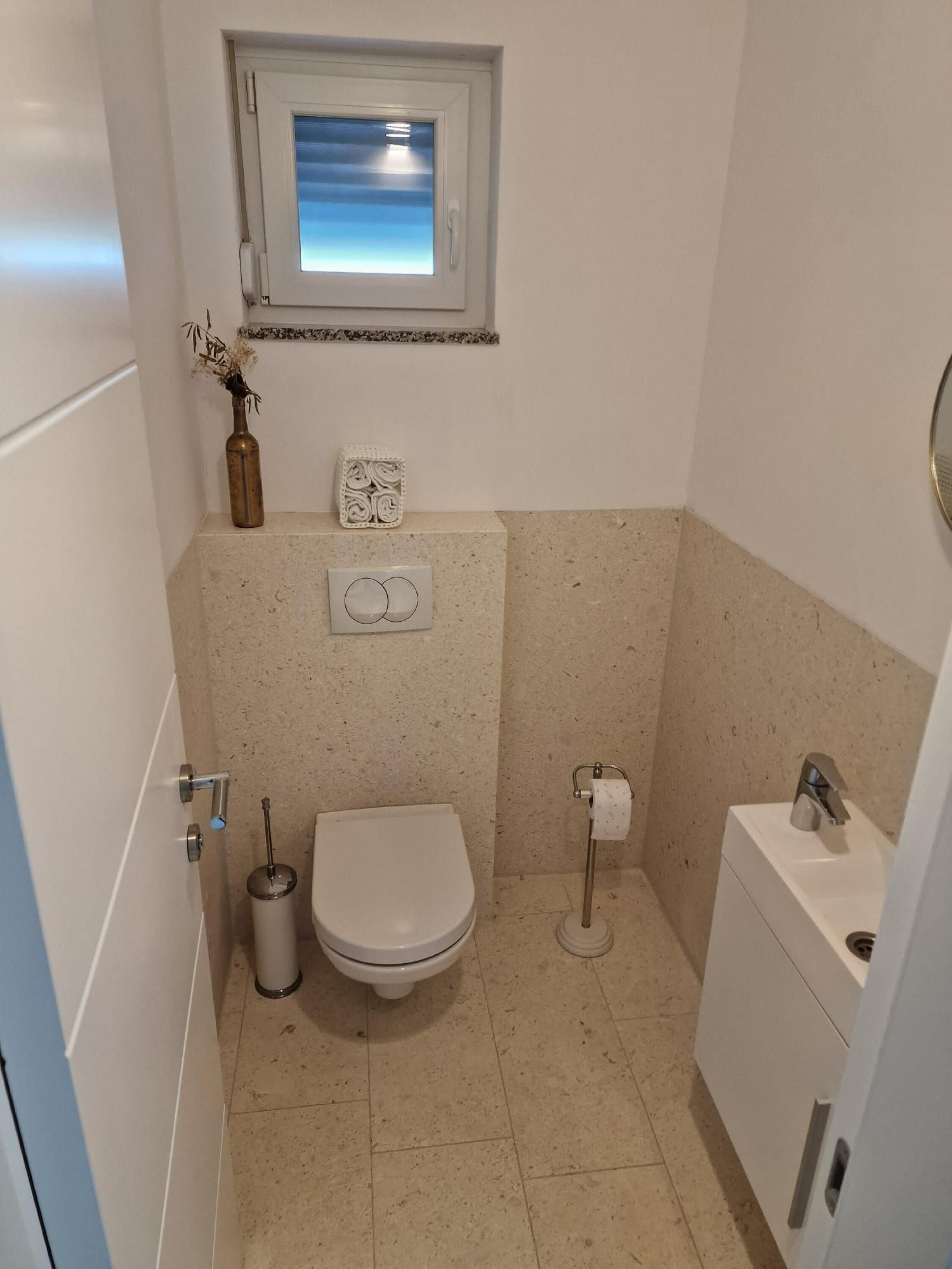 Un baño pequeño con inodoro, bidé y lavamanos.