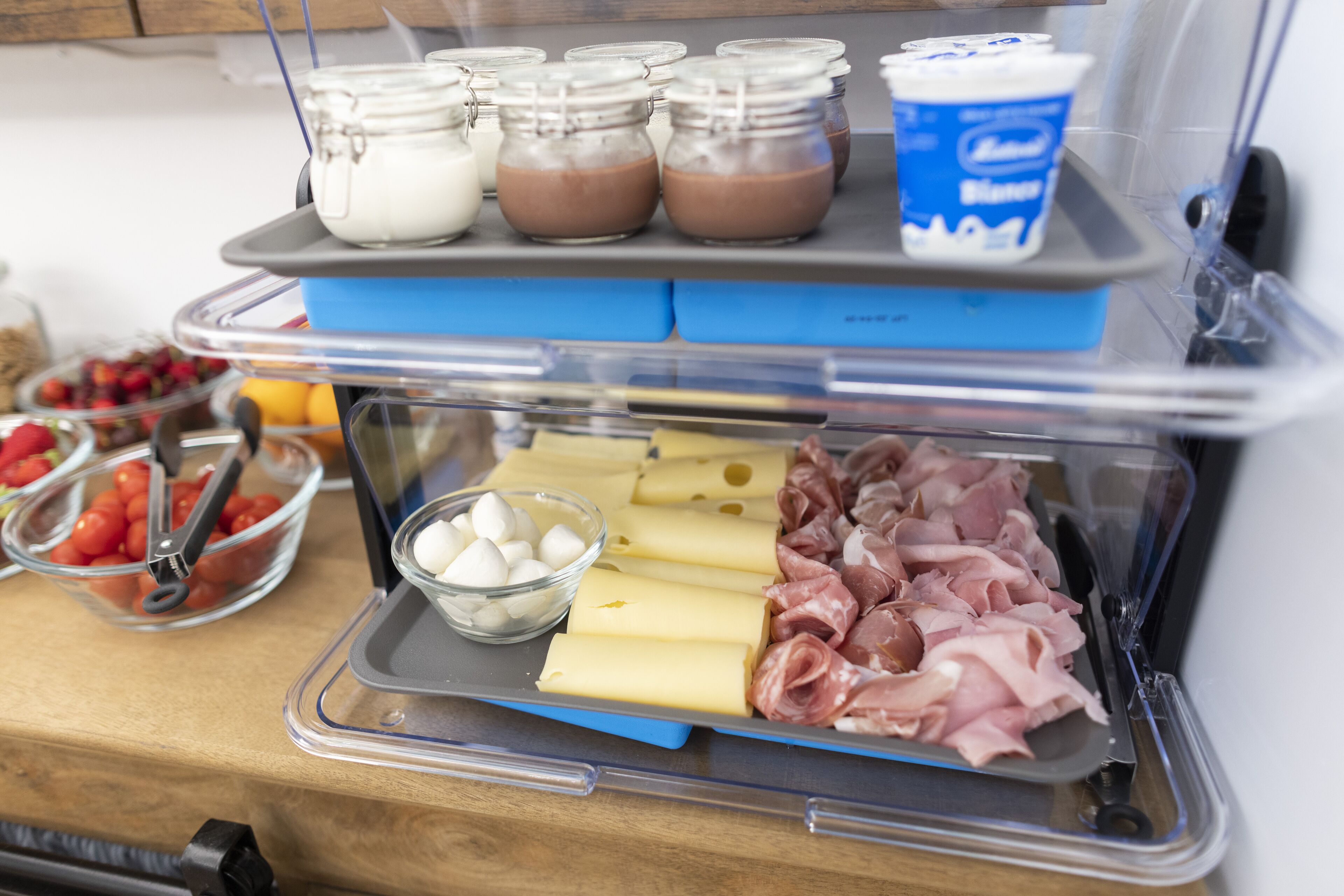 A food display with various items including cheese, meats, and jars of sauces.