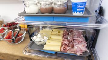 A food display with various items including cheese, meats, and jars of sauces.