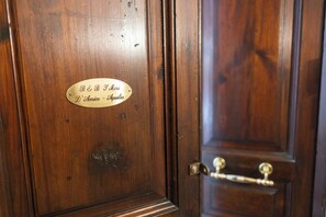 A wooden door with a brass handle and a brass plate with engraved text. - B&B I MORI (Catania)